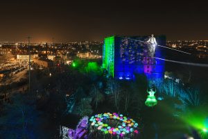 Cirque Bijou - Wire walker on a 40m high wire with the Bristol cityscape beneath him and a circle of colourful LED Umbrellas