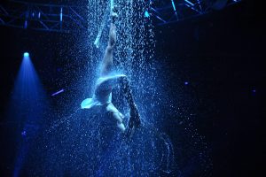Cirque Bijou - An aerialist performs in an atmospheric shower of water