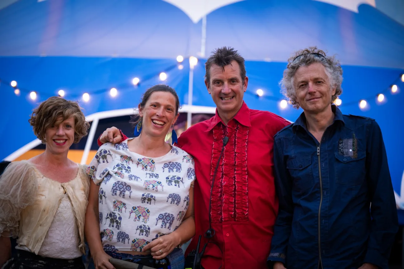 Geraldine, Kate, Julian and Billy stand posing in front of a blue Big Top 