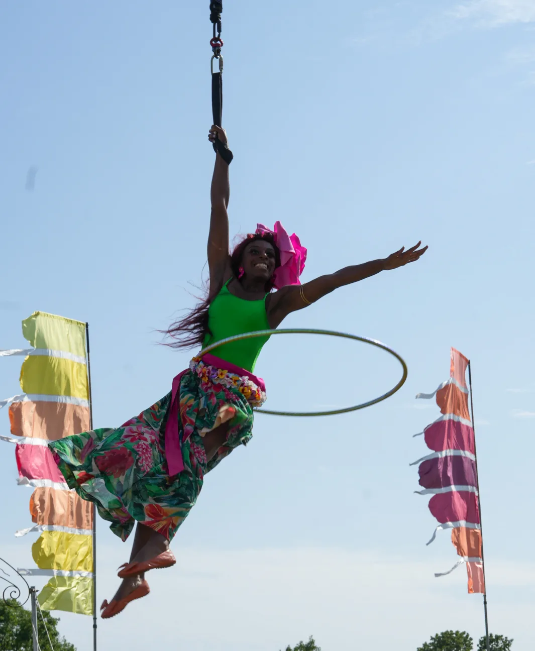 Camp Bestival performer Symone flying overhead with a hoola hoop circling her