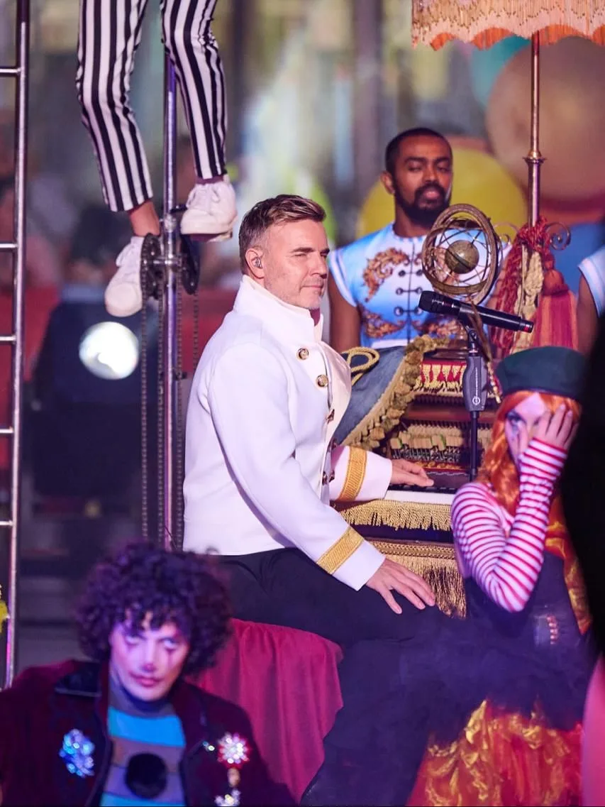 Take That performing surrounded by circus artists
