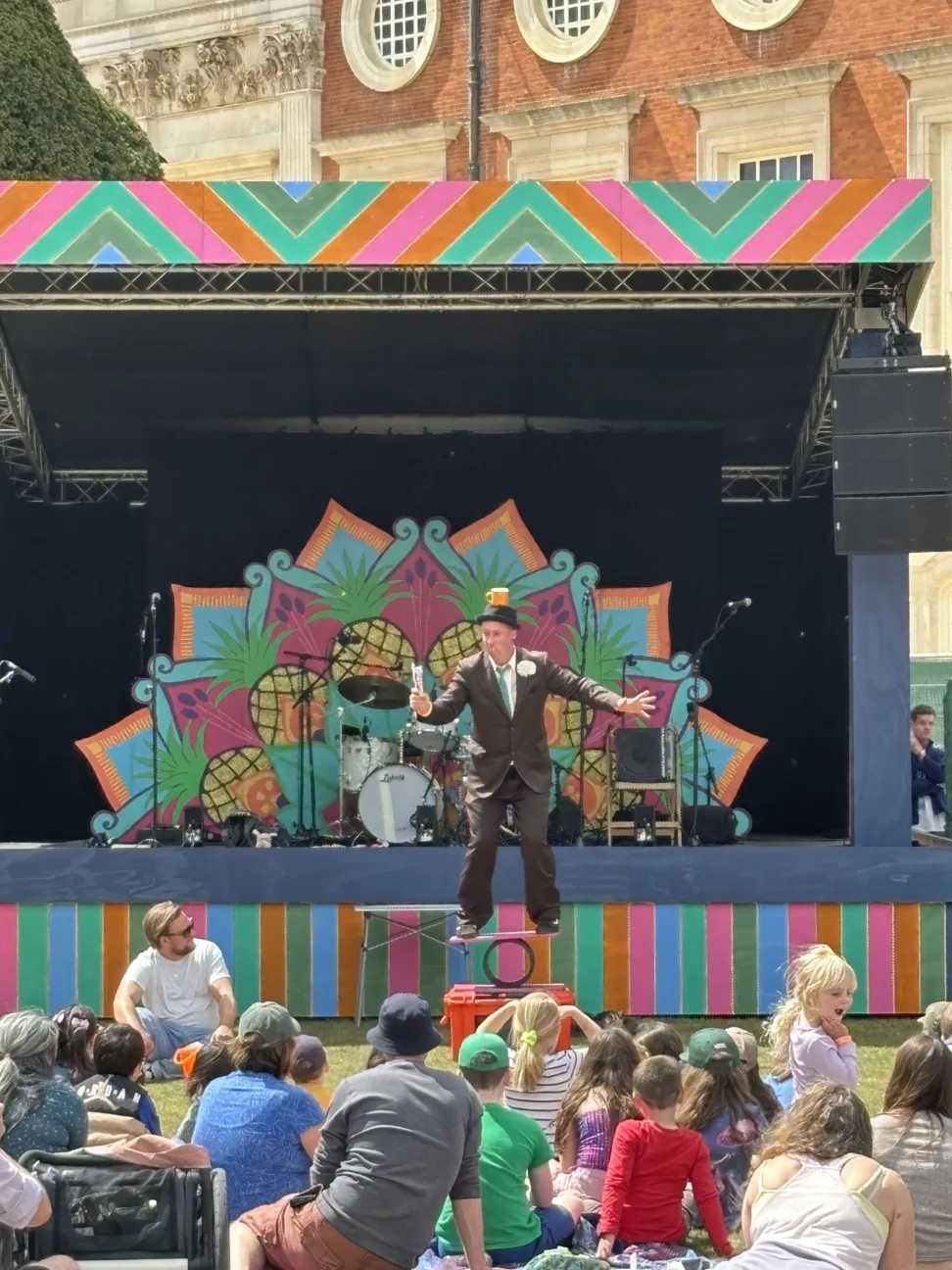 Children watching a performer balancing on a rola bola board