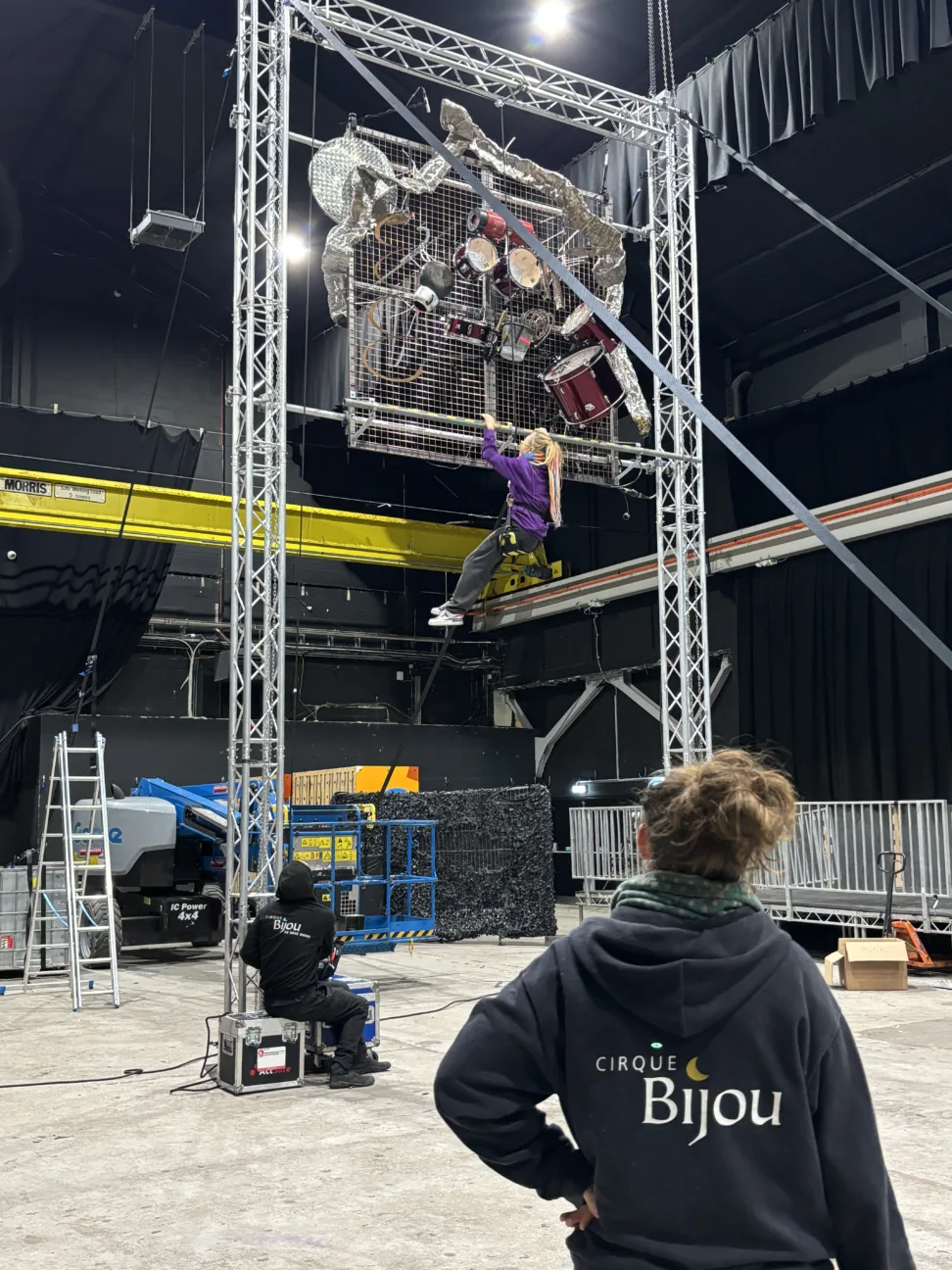 Picture of a Cirque Bijou crew member looking up at the aerial drumming rig