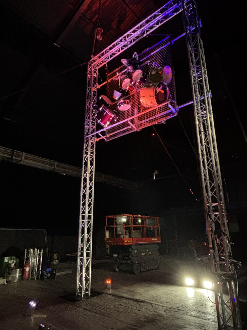 wide shot of the aerial drum rig with coloured lighting