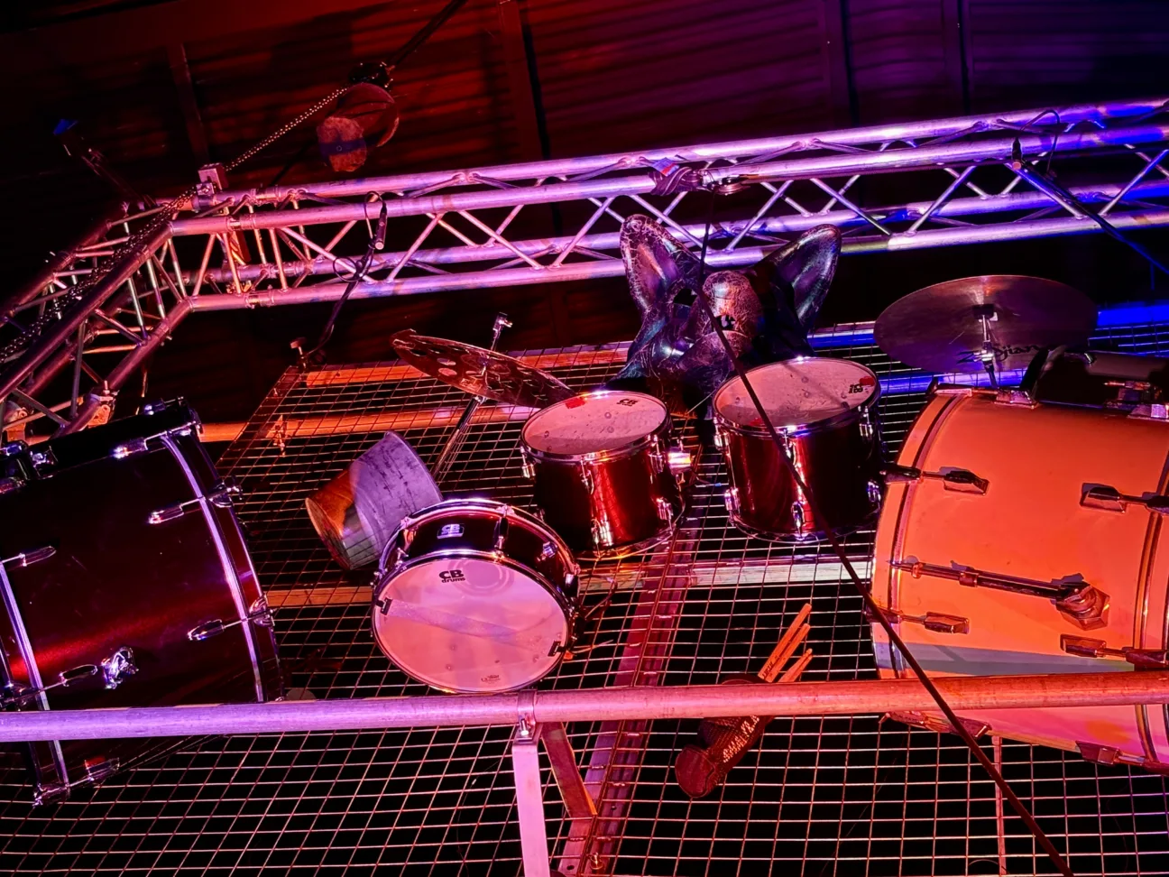 Close up photo of the drum rig bathed in orange and purple light
