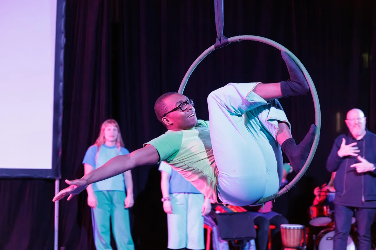 a perfomer inside an aeral hoop smiling