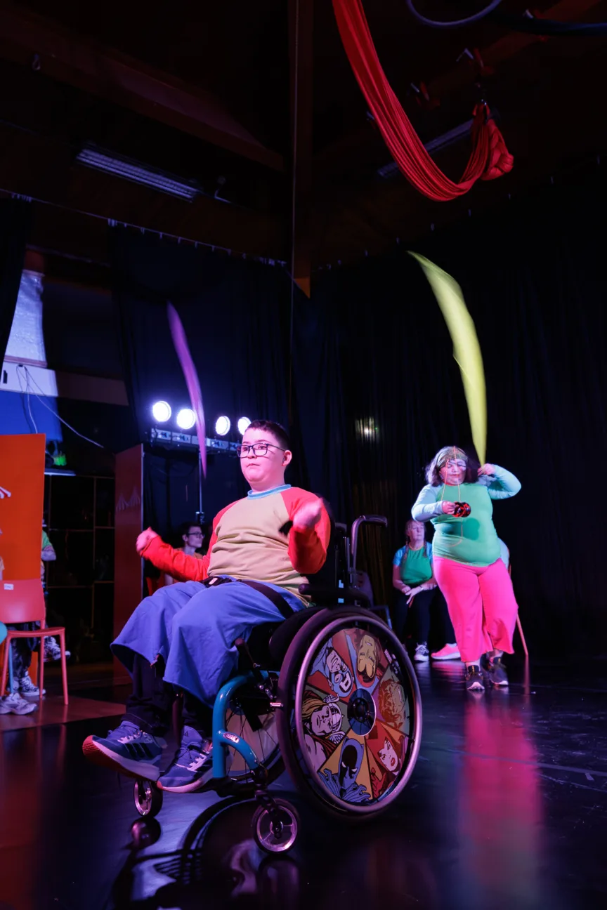 a disabled performer in a wheelchair using poi ribbons