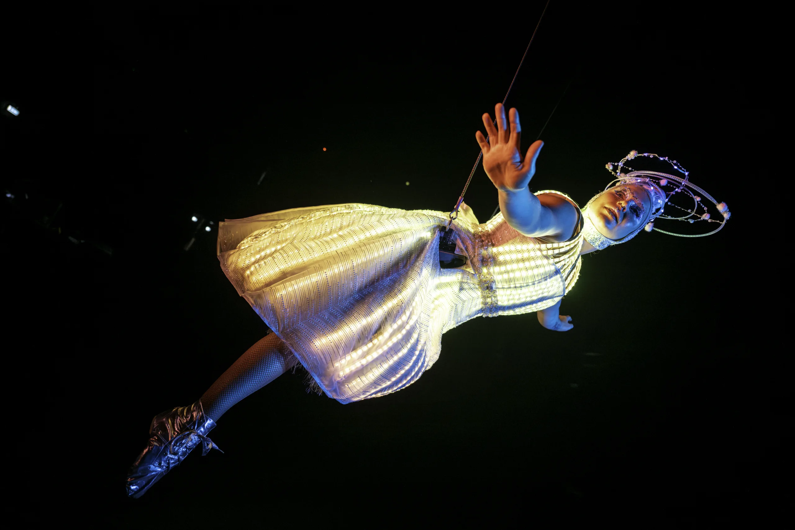 Saskia Collyns in our LED dress lit up floating on wire to a black background